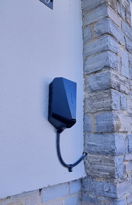 A wall-mounted home EV charger fitted to the exterior wall of a UK home